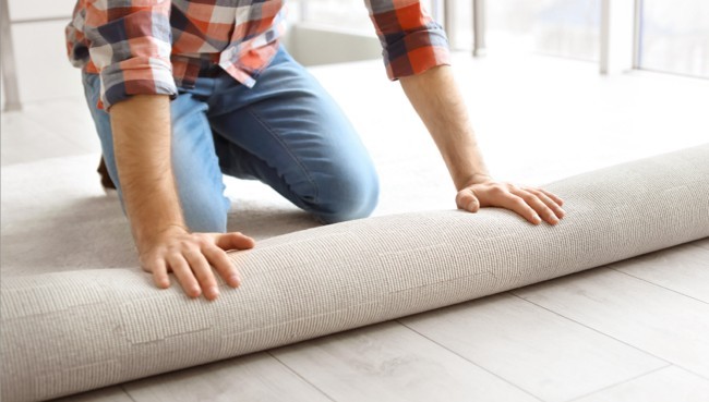 Man rolling carpet for installation | Cleveland Carpets and Floors