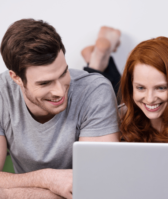 Happy couple with laptop | Cleveland Carpets and Floors